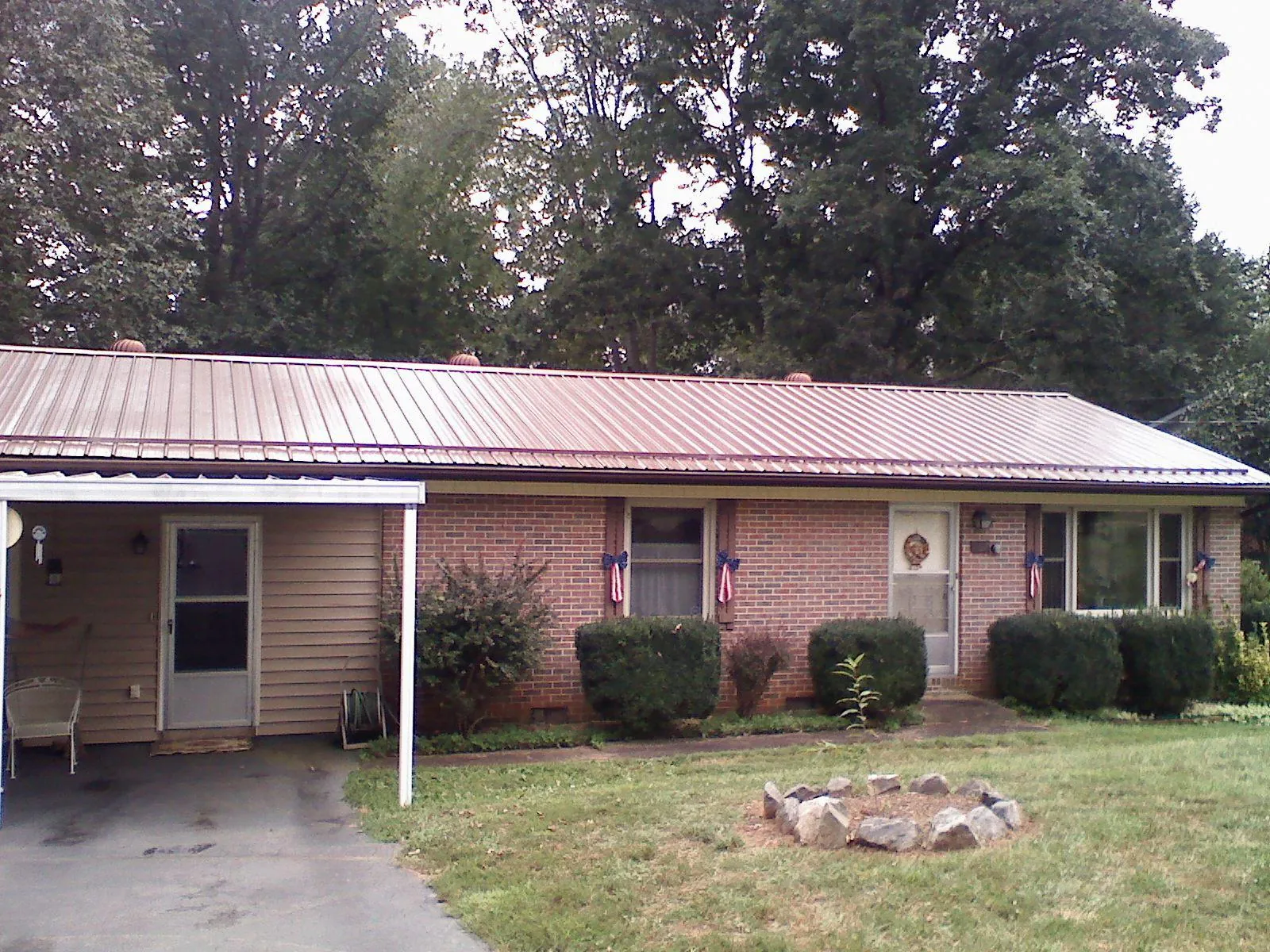 Bronze metal roof and carport on a brick ranch home — Roof Repair work by our crew in Council